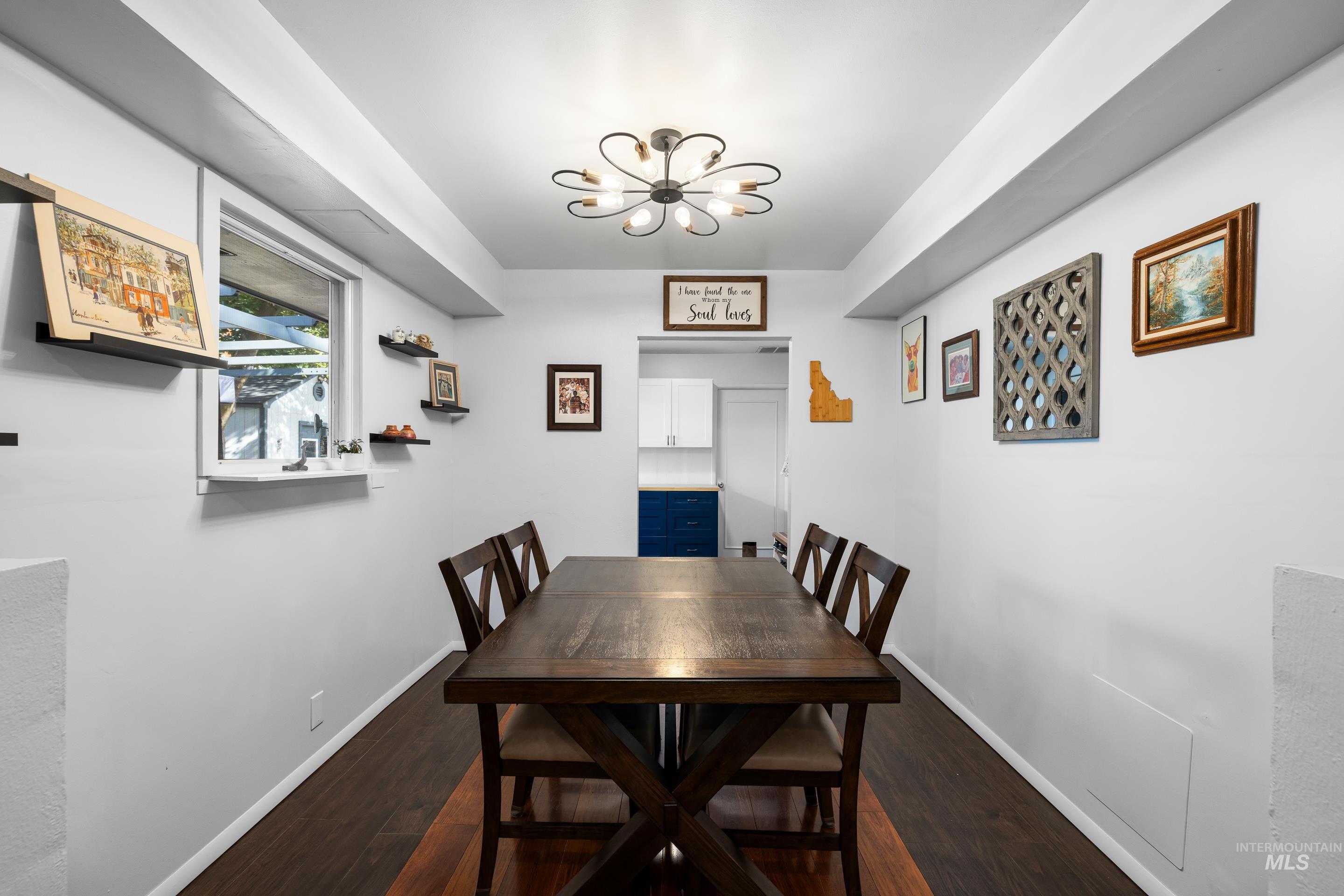 Dining room with a chandelier and dark wood-type flooring