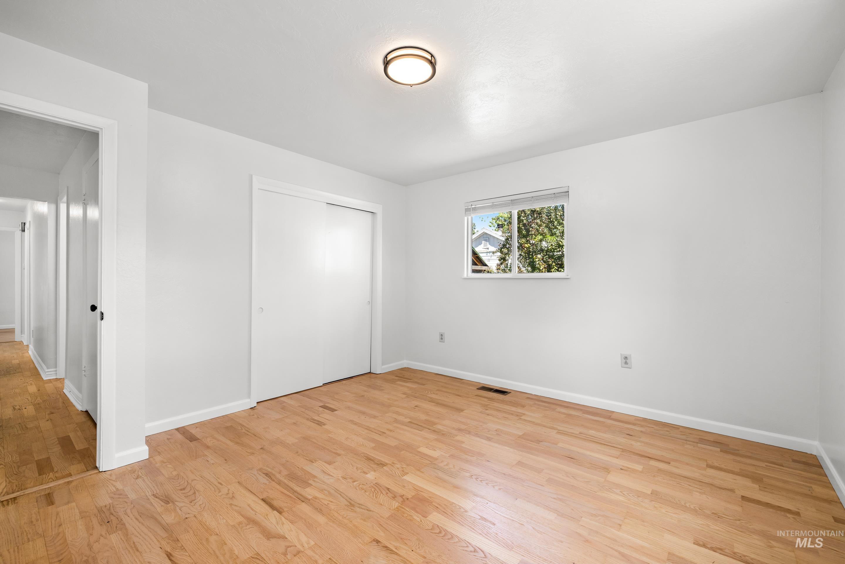 Unfurnished bedroom featuring light wood-style flooring and a closet