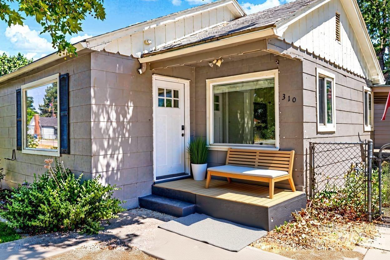 Property entrance featuring a deck, roof with shingles, and a gate