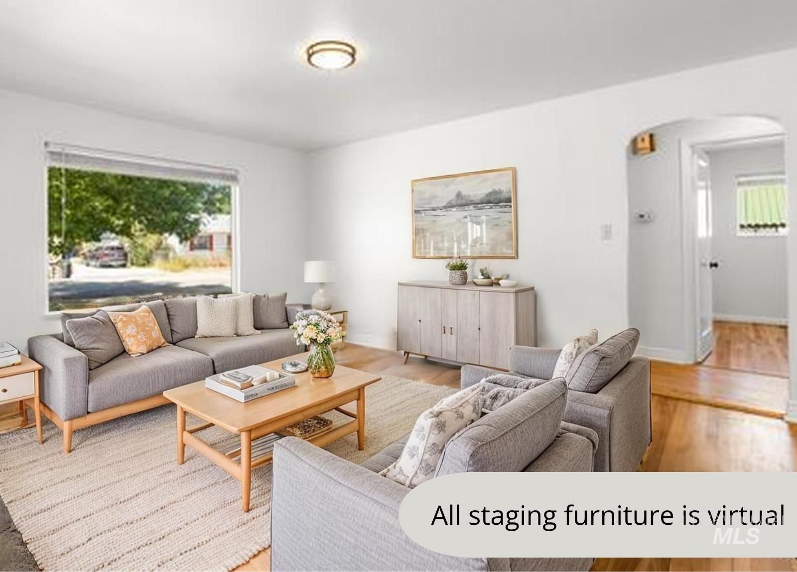 Living area featuring arched walkways, healthy amount of natural light, and light wood-style flooring