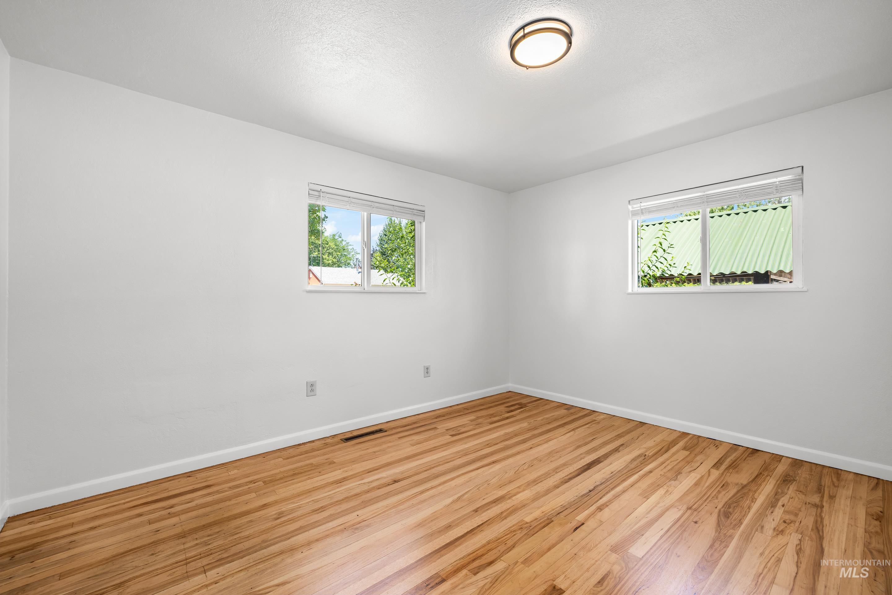 Unfurnished room with baseboards and wood finished floors