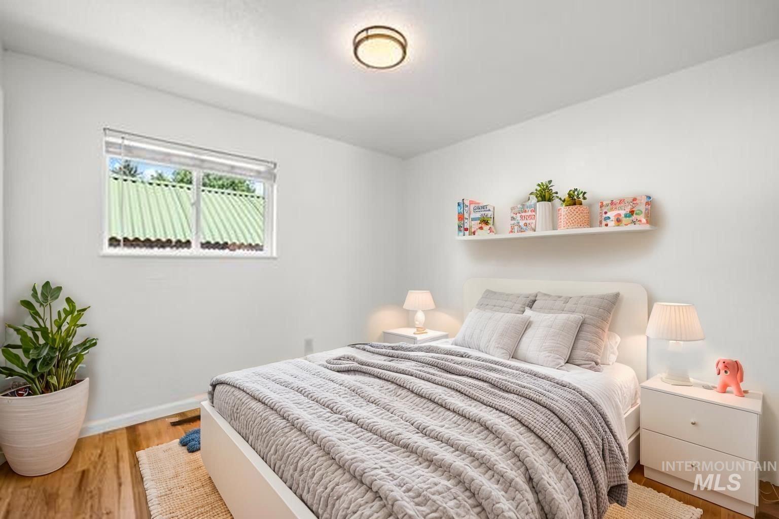 Bedroom with wood finished floors and baseboards