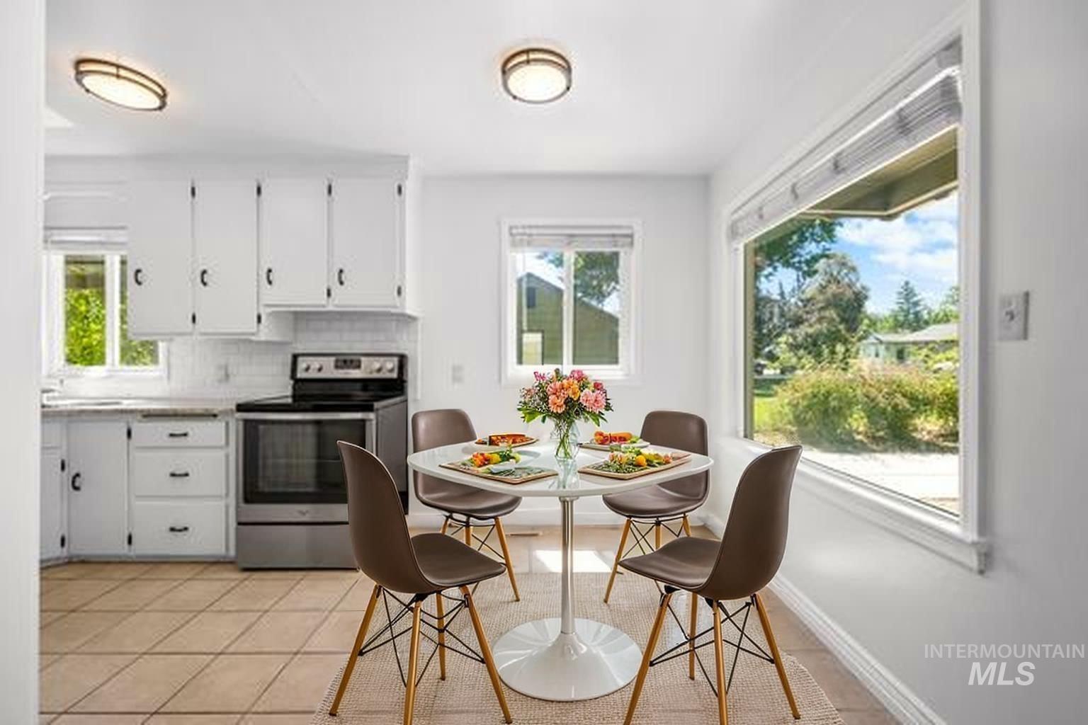 Kitchen featuring stainless steel range with electric stovetop, plenty of natural light, white cabinets, and decorative backsplash