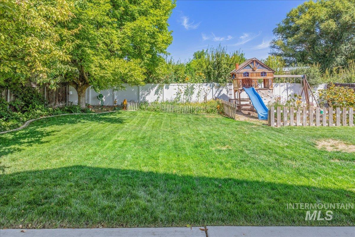 Fenced backyard with a playground