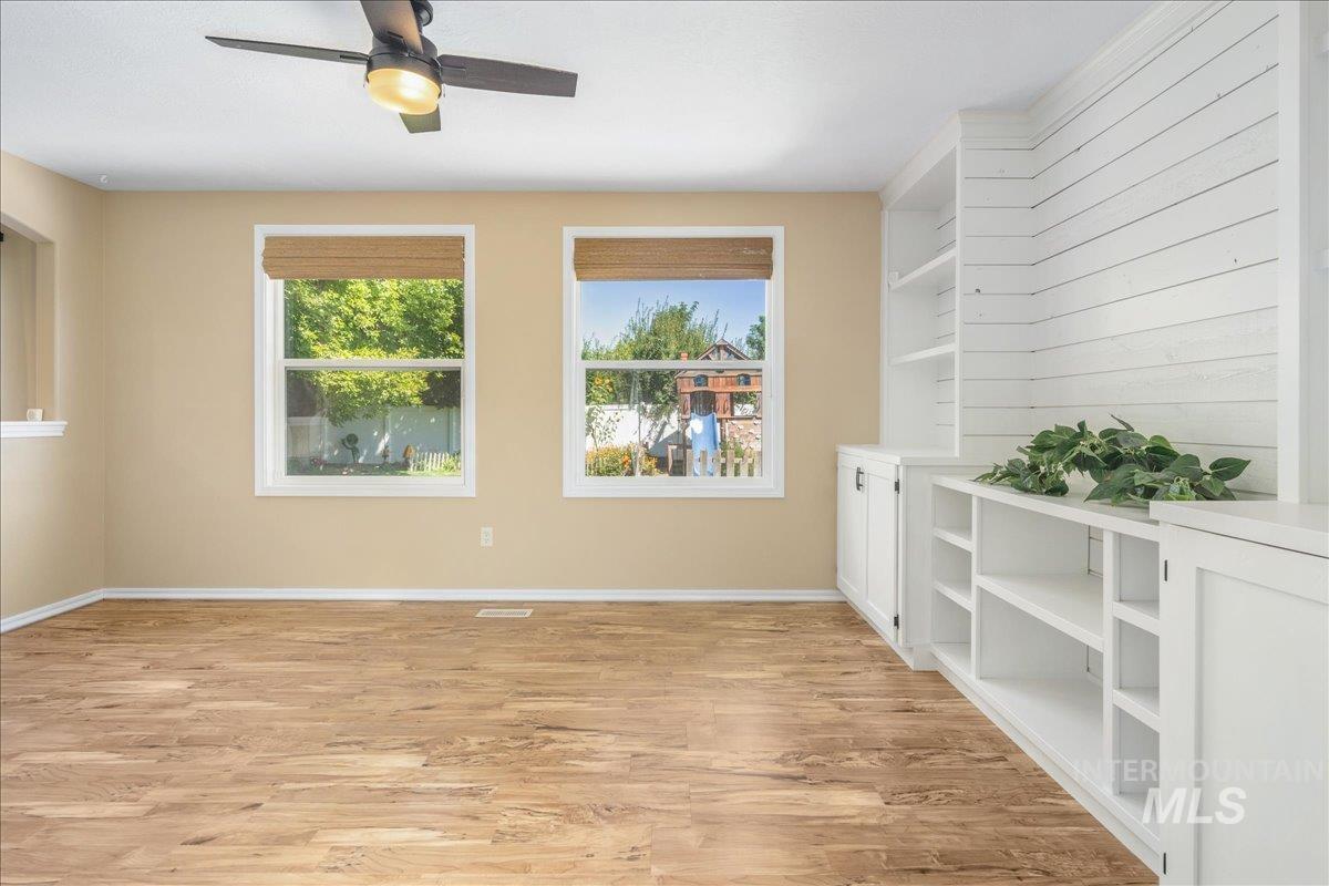 Empty room featuring light wood-type flooring and ceiling fan