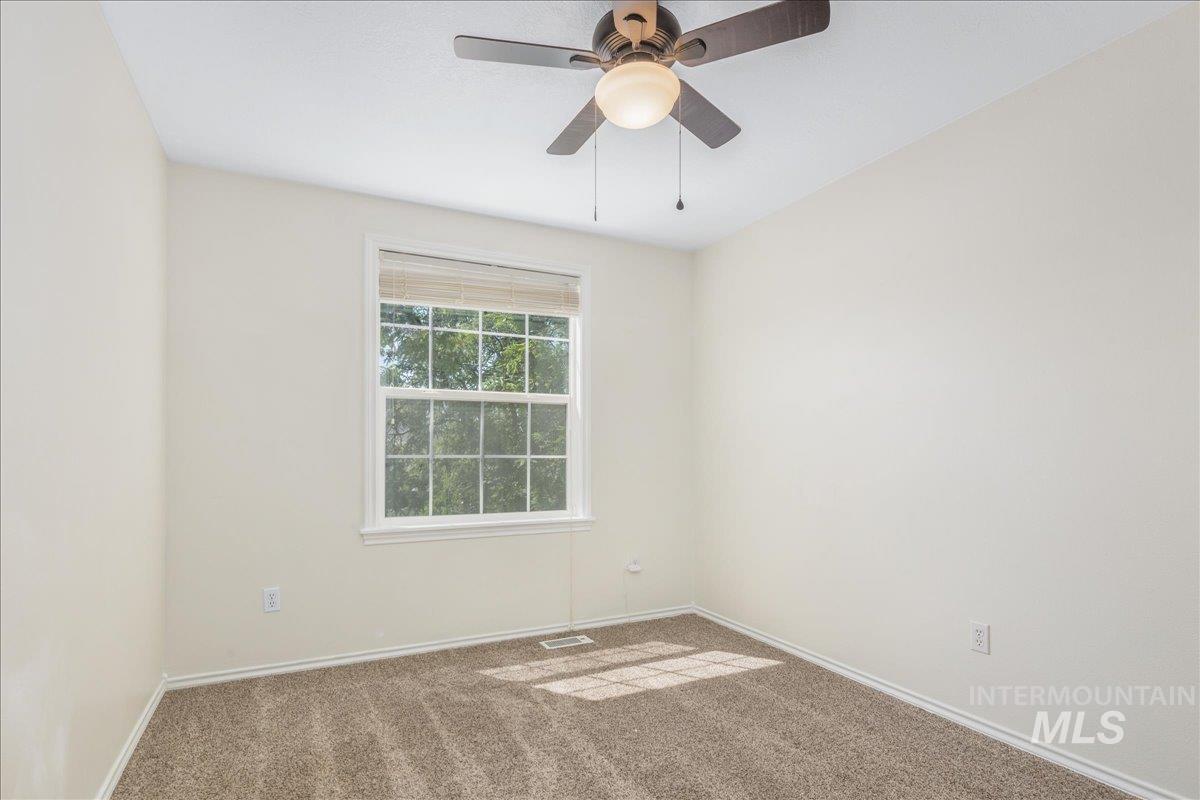 Spare room with carpet floors and a ceiling fan