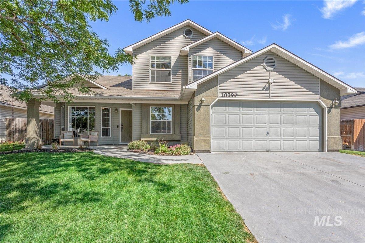 Traditional home featuring a garage, a porch, and concrete driveway