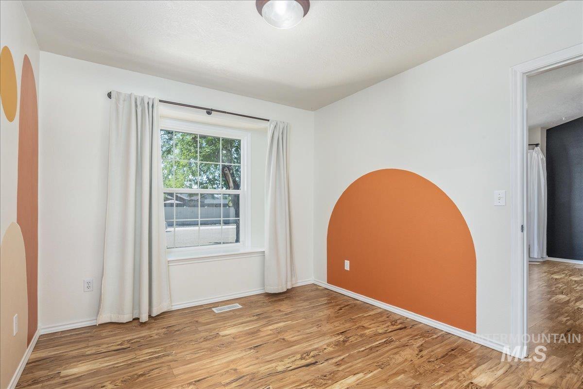 Spare room featuring light wood-style floors and baseboards