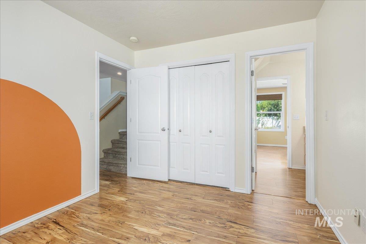 Unfurnished bedroom featuring light wood finished floors and a closet