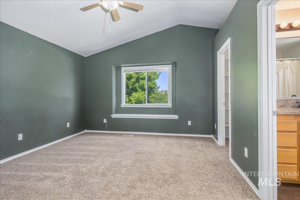 Unfurnished bedroom featuring lofted ceiling, carpet, and ceiling fan