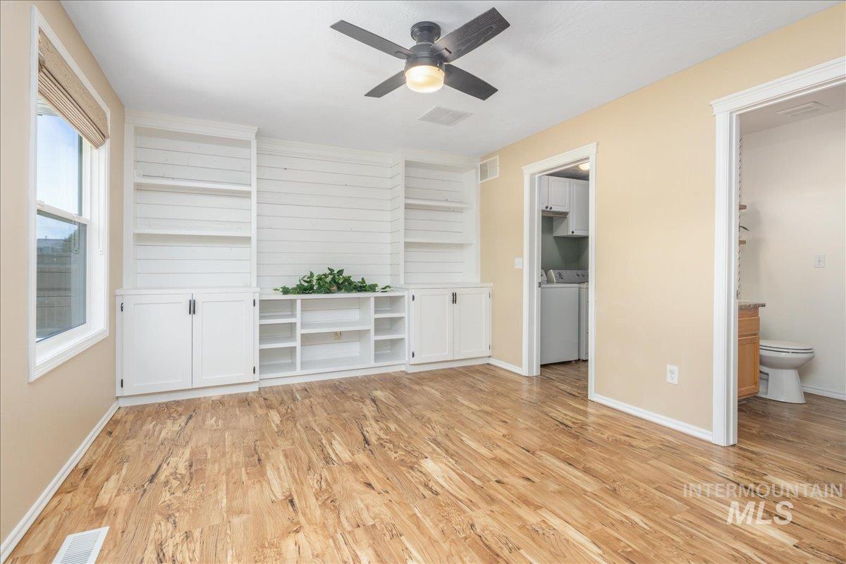 Unfurnished living room featuring light wood-style floors and ceiling fan
