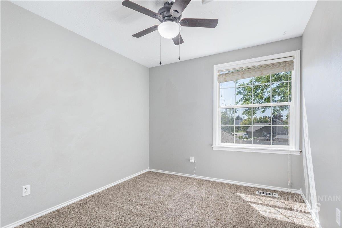 Unfurnished room featuring light colored carpet and ceiling fan
