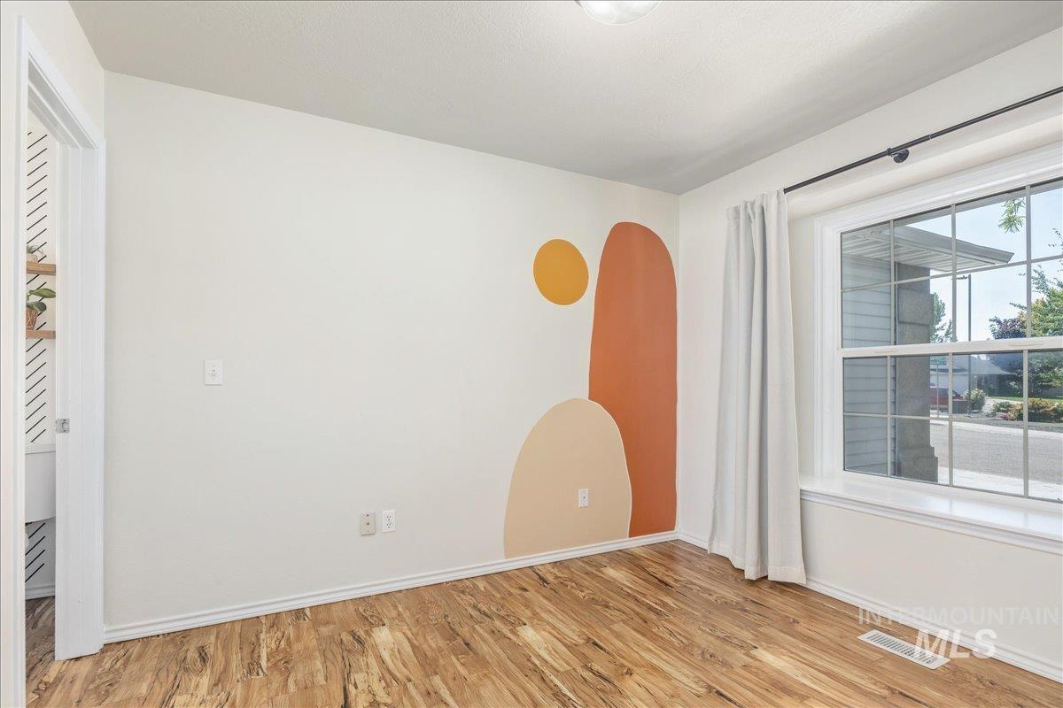 Empty room featuring light wood-style flooring and arched walkways