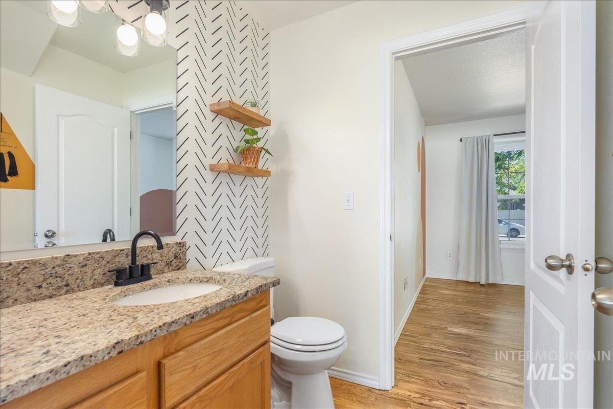 Half bath featuring light wood-style floors, vanity, and a chandelier