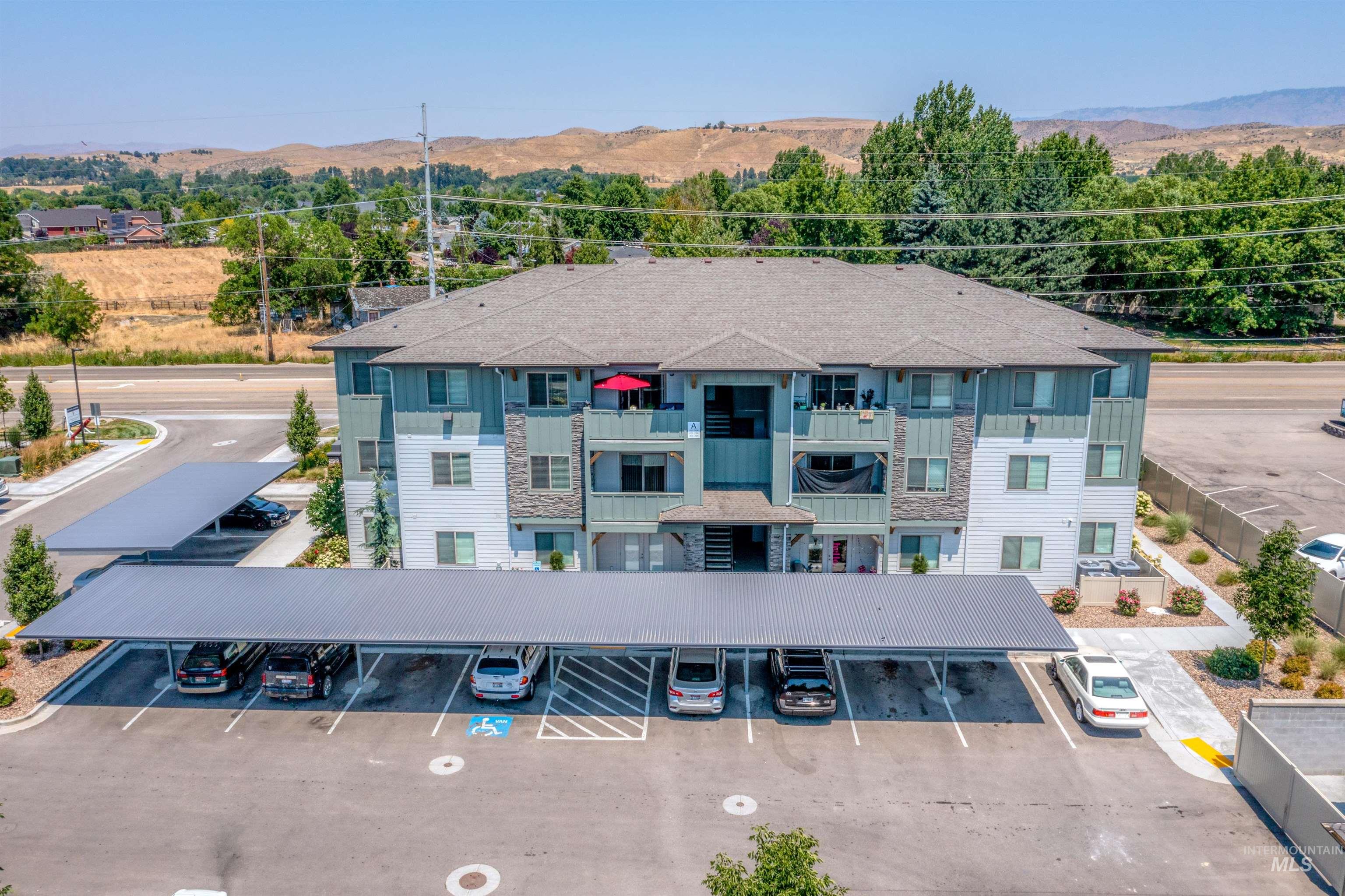 View of property with covered and uncovered parking