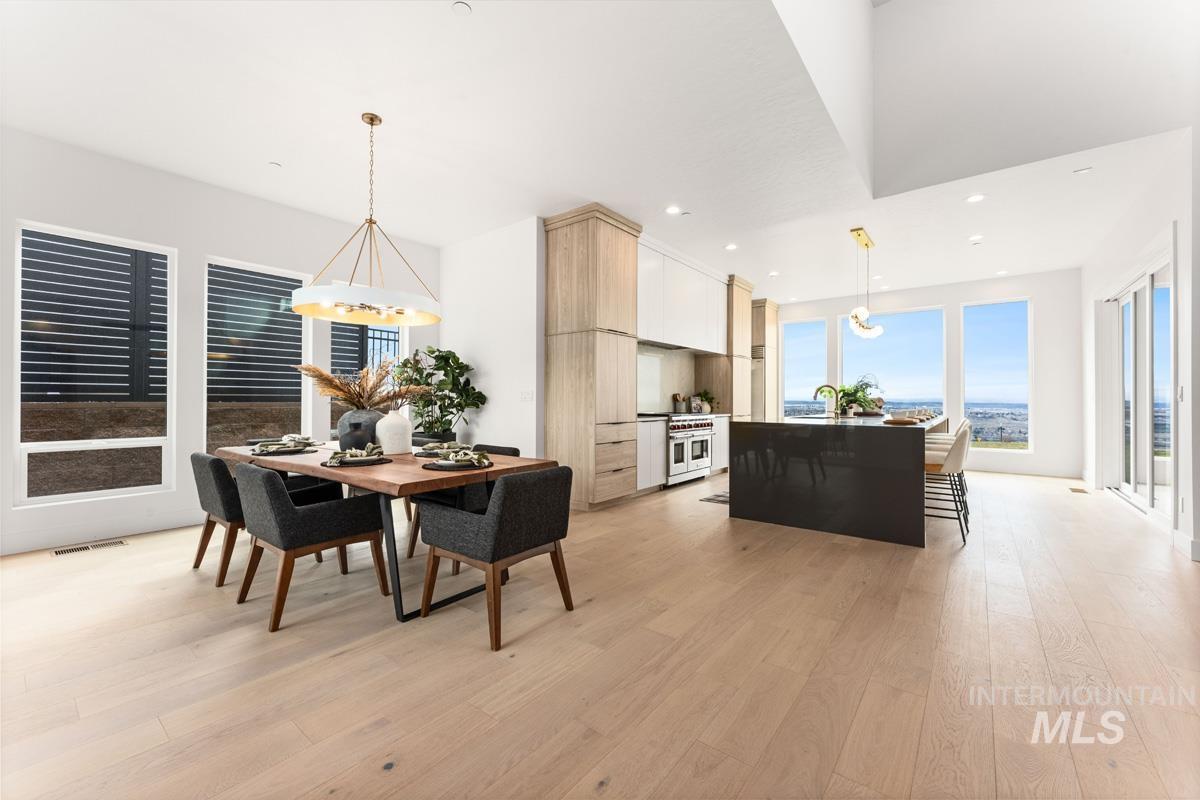 Dining room with light wood finished floors, plenty of natural light, and suspended lighting