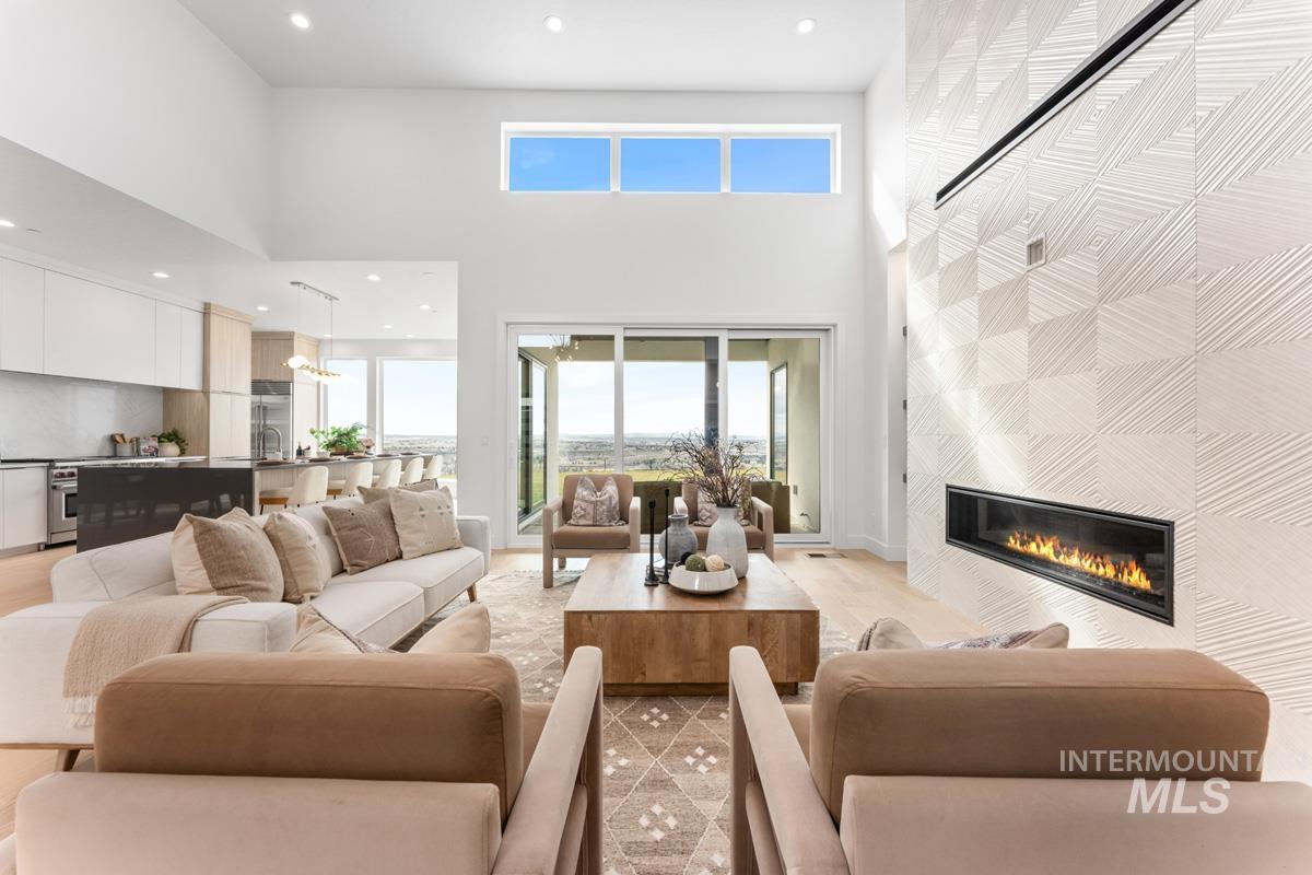 Living area with recessed lighting, a high ceiling, plenty of natural light, and a tiled fireplace