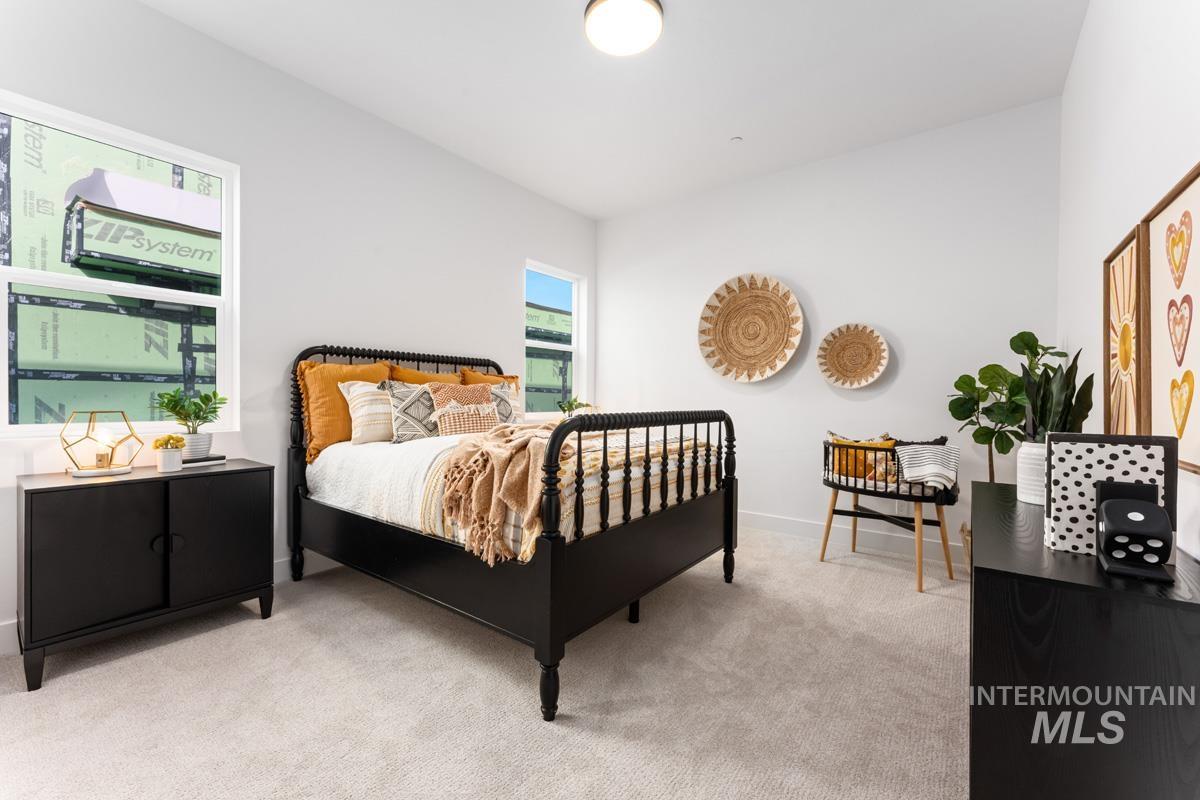 Bedroom featuring light colored carpet and baseboards