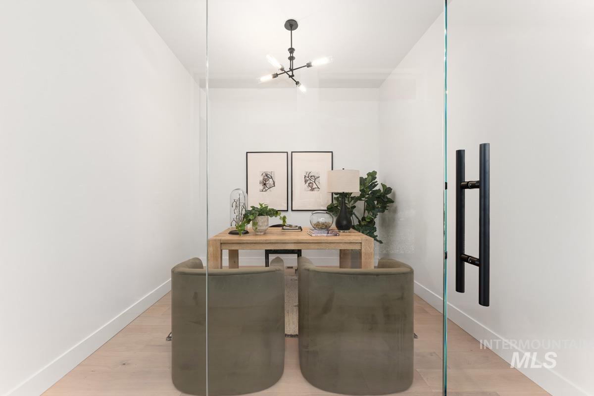 Office space with light wood finished floors and a chandelier