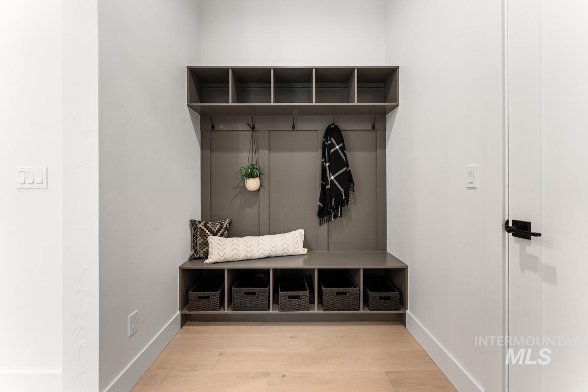 Mudroom featuring light wood-style flooring and baseboards