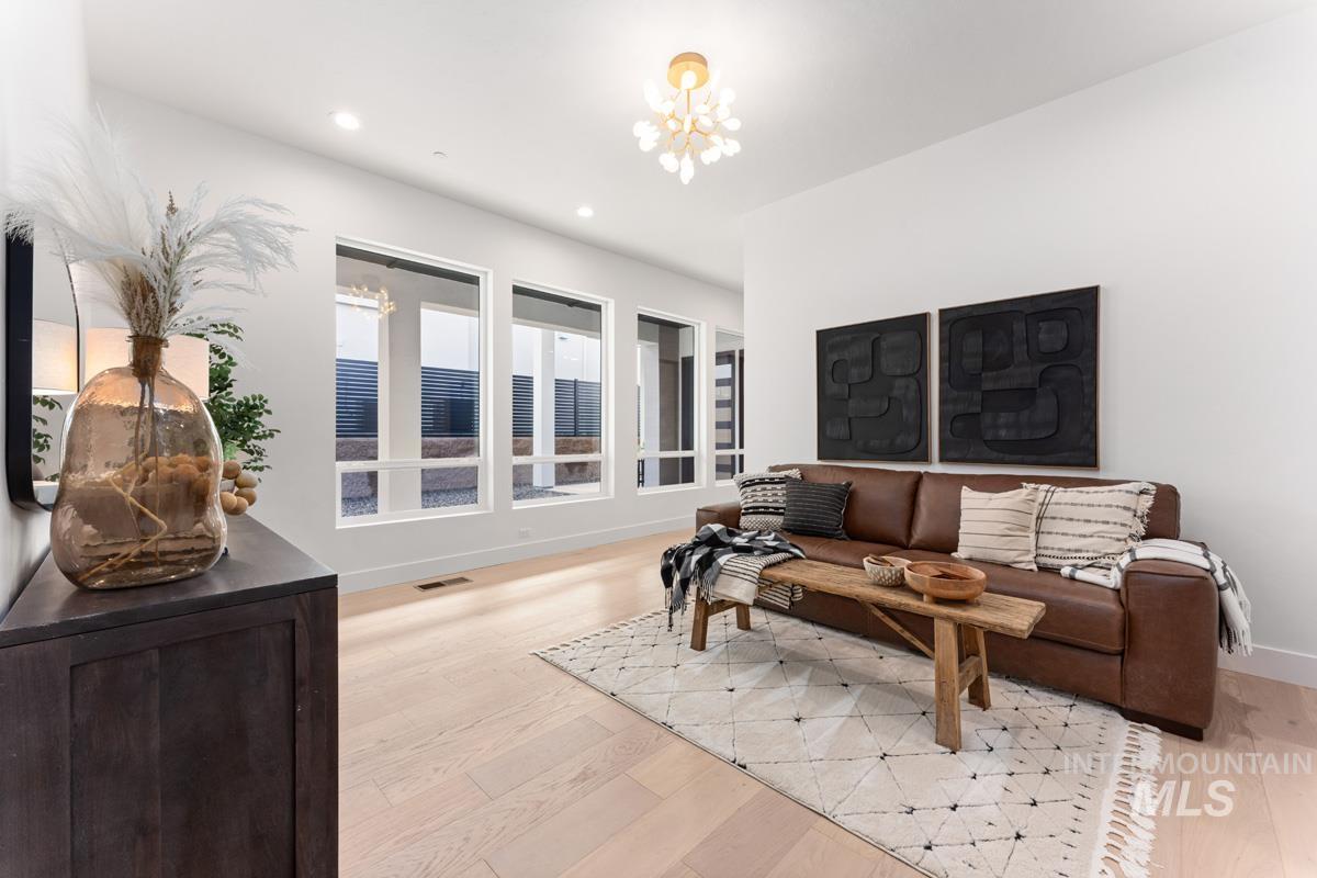 Living area with light wood-type flooring and hanging lights