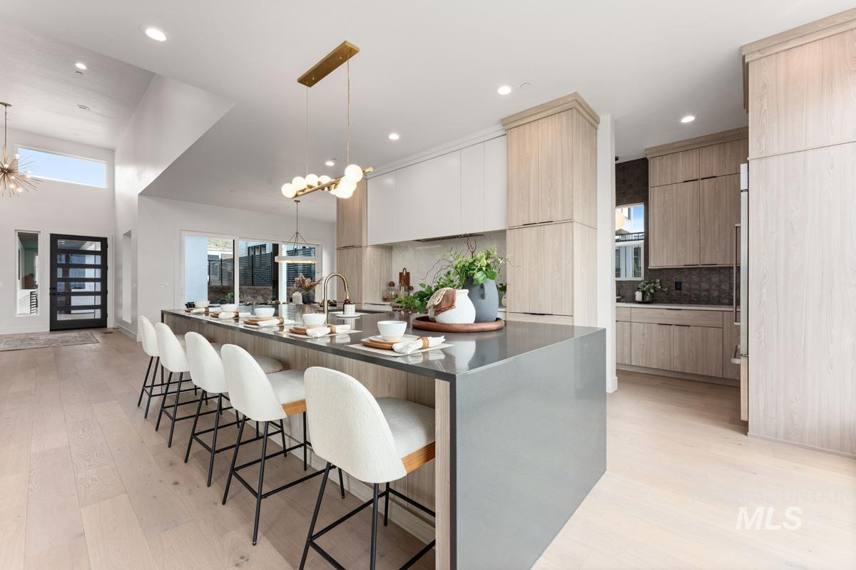 Kitchen featuring modern cabinets, a kitchen breakfast bar, and light wood-style floors