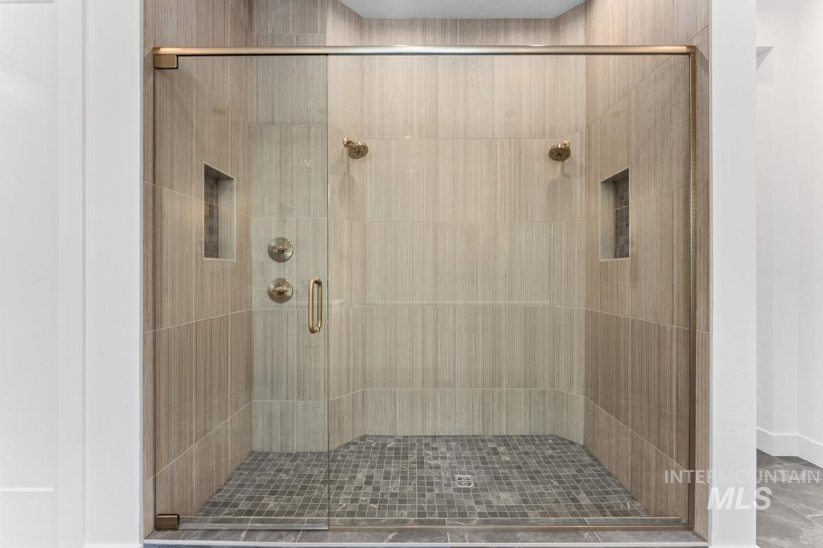 Full bathroom with a shower stall and baseboards