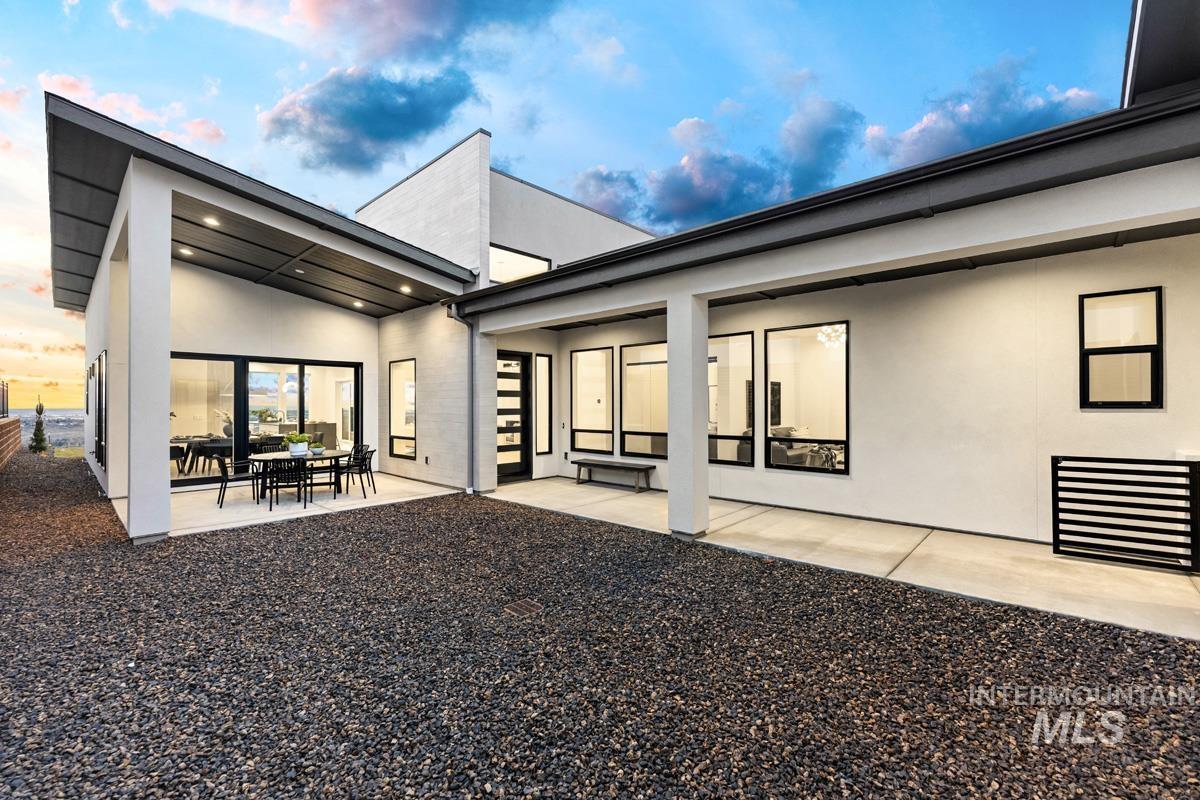 Rear view of house featuring a patio, stucco siding, and outdoor dining space