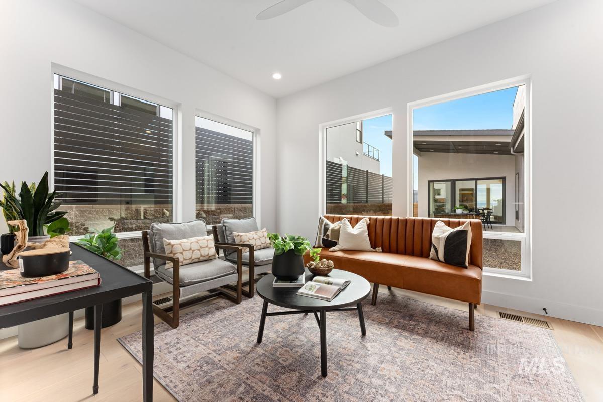 Living area with light wood-style floors, plenty of natural light, recessed lighting, and ceiling fan