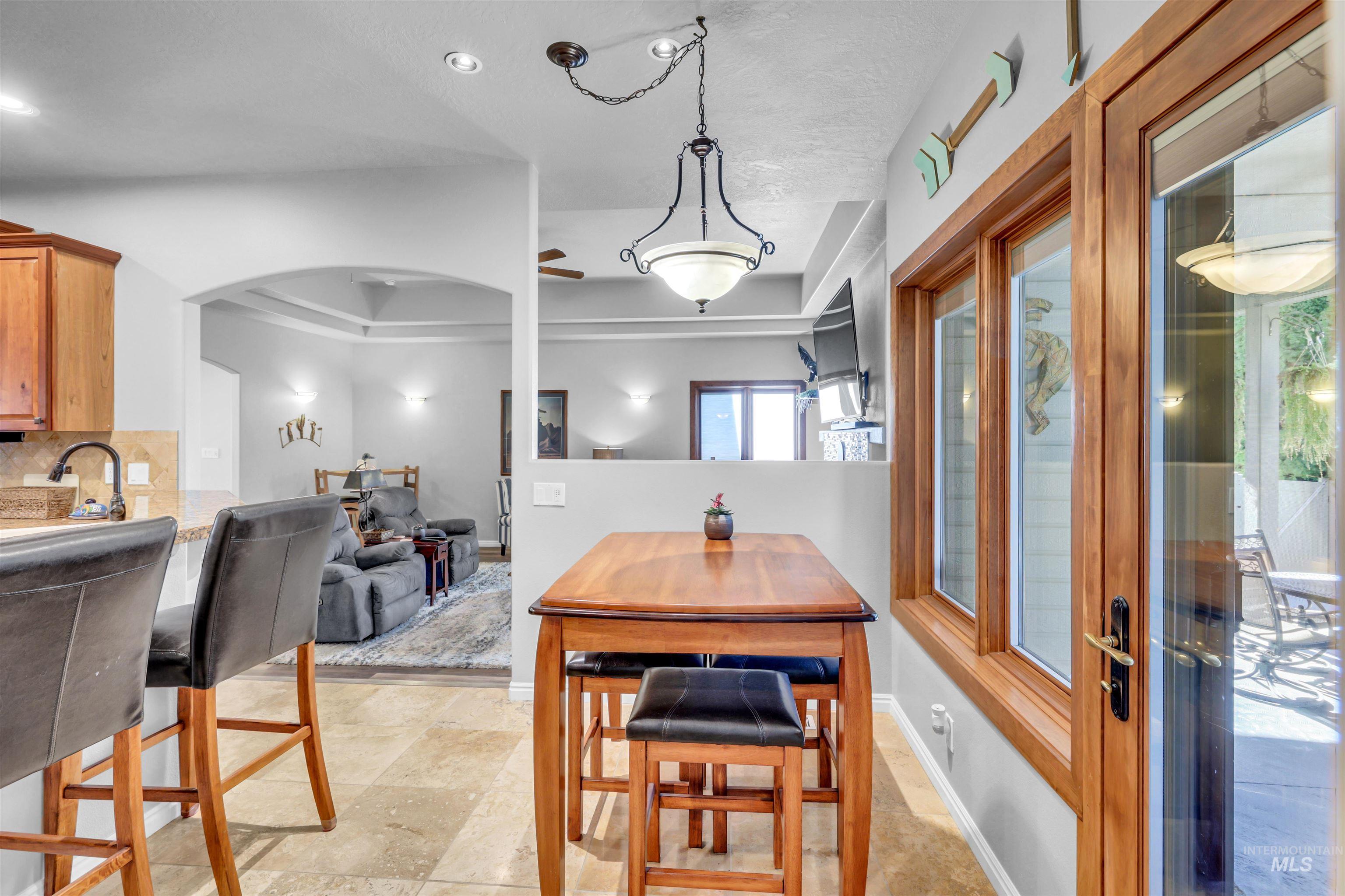 Dining room featuring arched walkways and a tray ceiling
