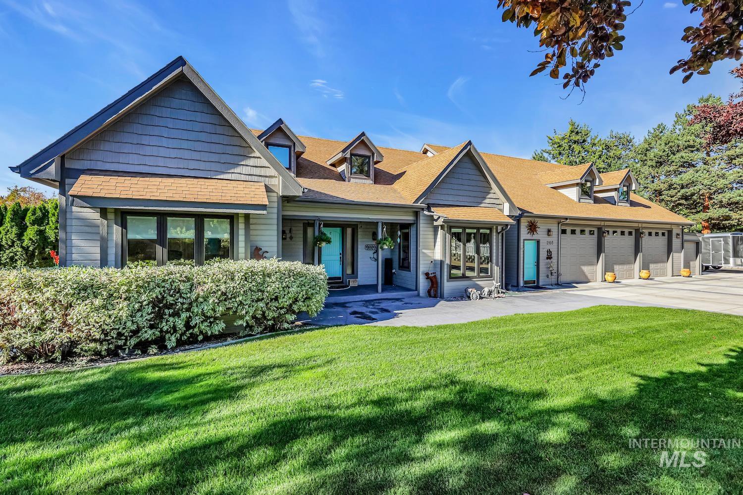 View of front of property with a front lawn, roof with shingles, a porch, and driveway