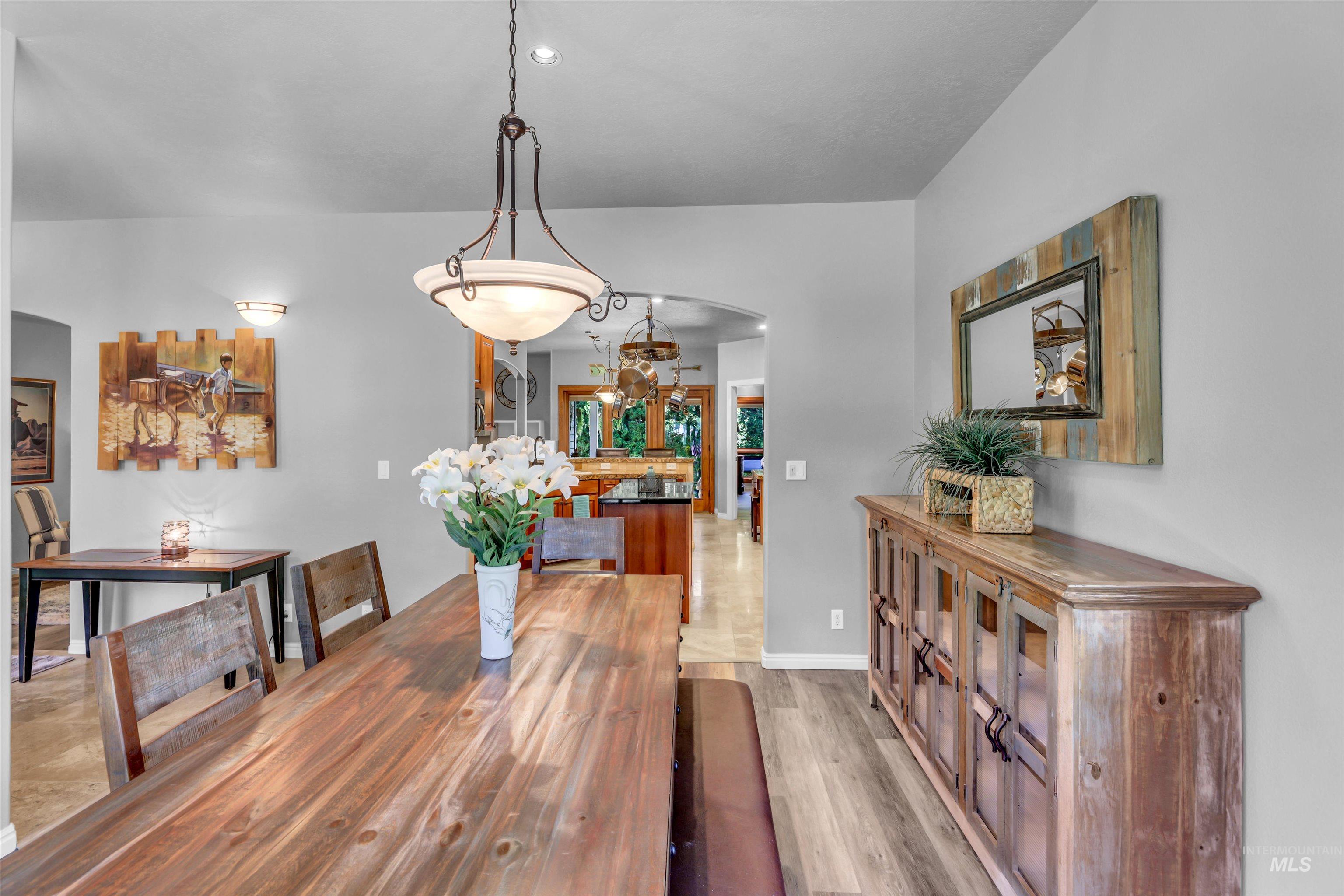 Dining room featuring arched walkways and light wood-type flooring