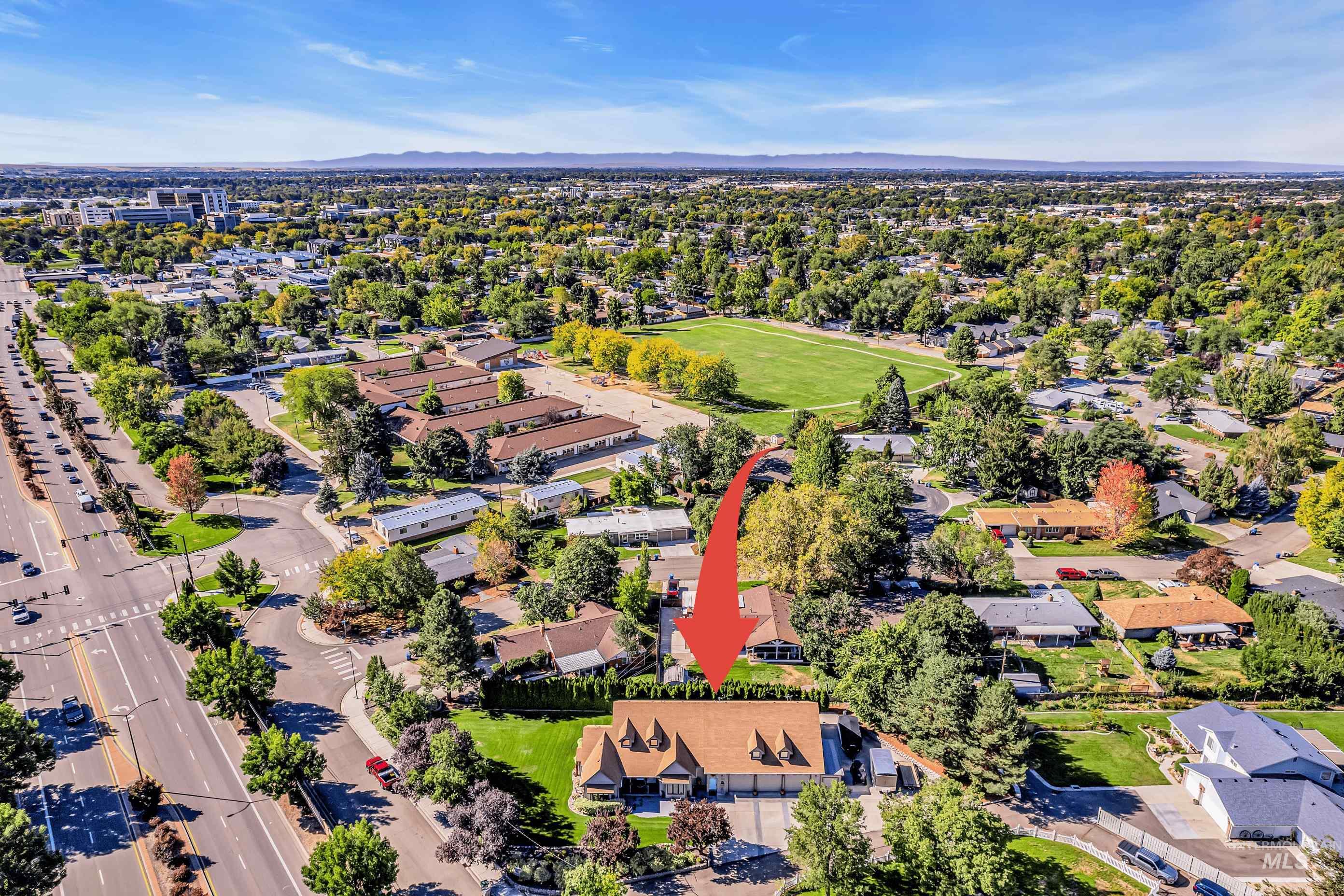 Aerial overview of property's location with nearby suburban area and mountains