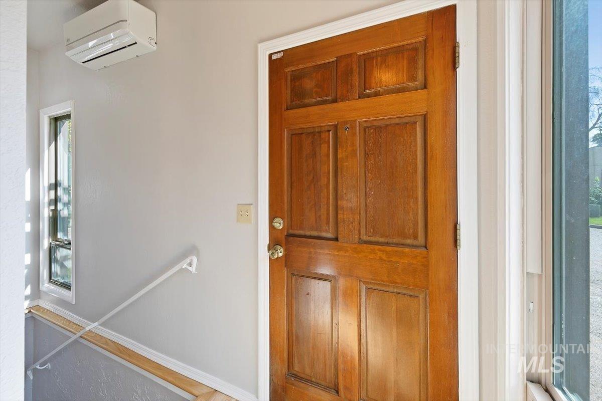 View of exterior entry featuring an AC wall unit