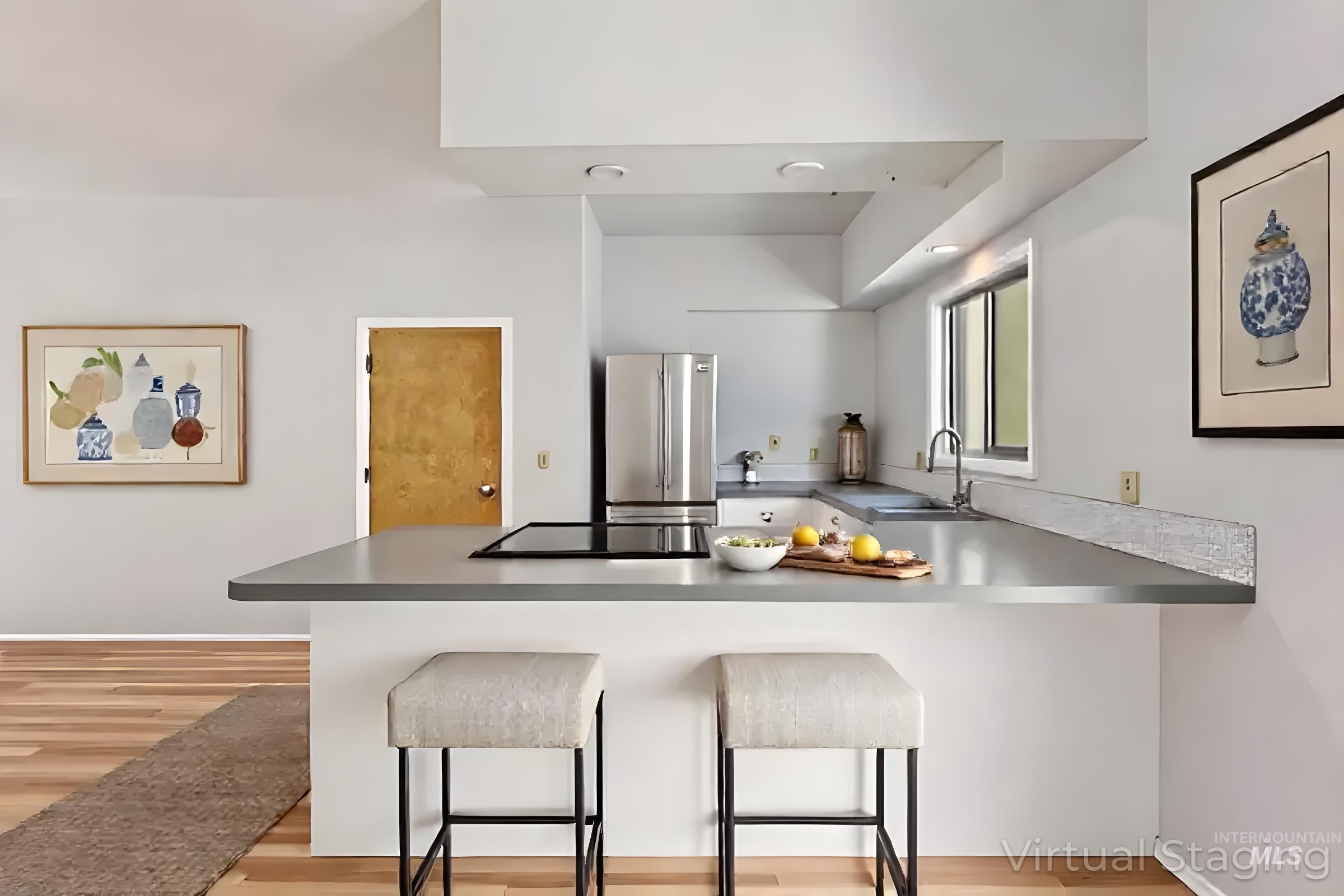 Kitchen featuring a peninsula, a kitchen breakfast bar, light wood finished floors, freestanding refrigerator, and recessed lighting