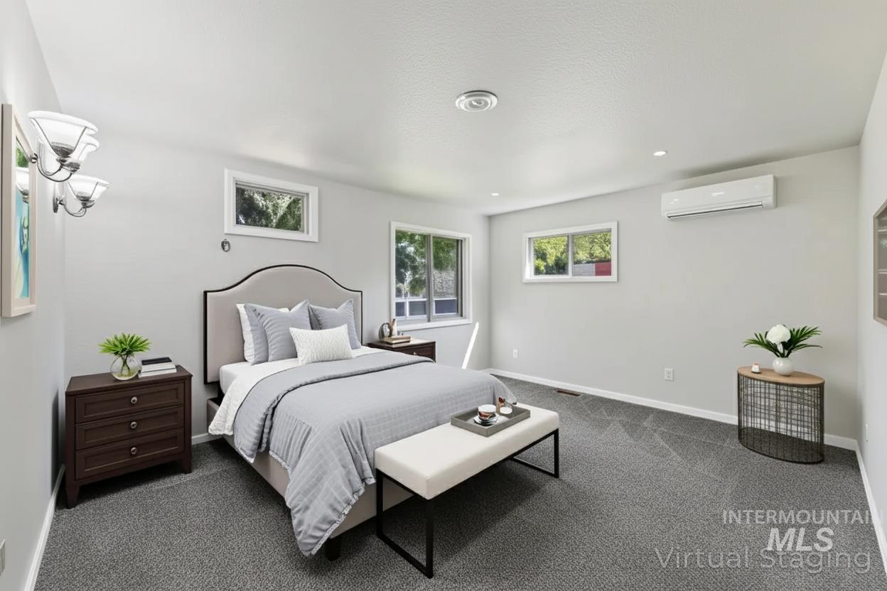 Bedroom with dark carpet, a wall unit AC, a textured ceiling, and recessed lighting
