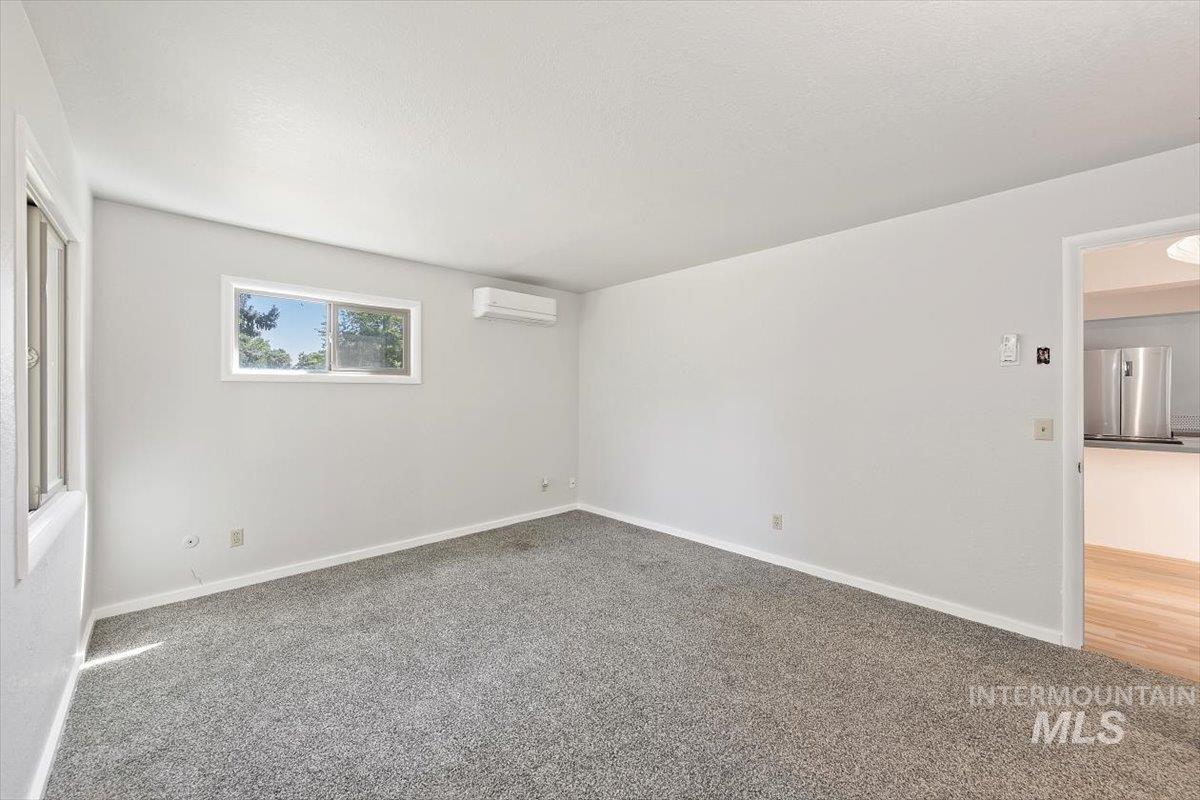 Spare room featuring carpet and a wall unit AC