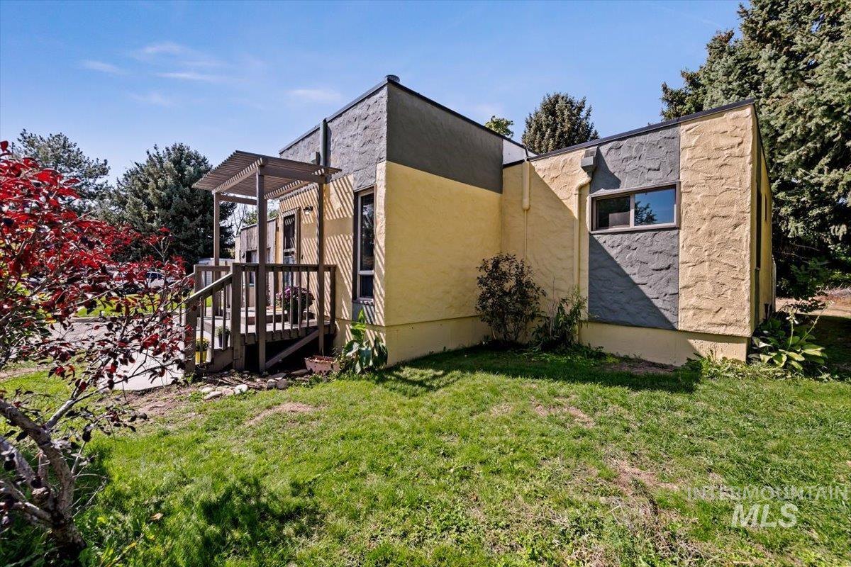View of side of home featuring a lawn and stucco siding