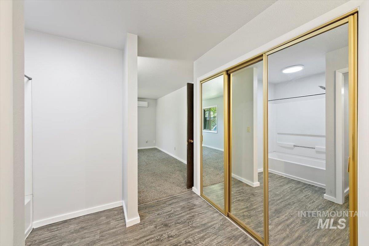 Doorway featuring baseboards and wood finished floors