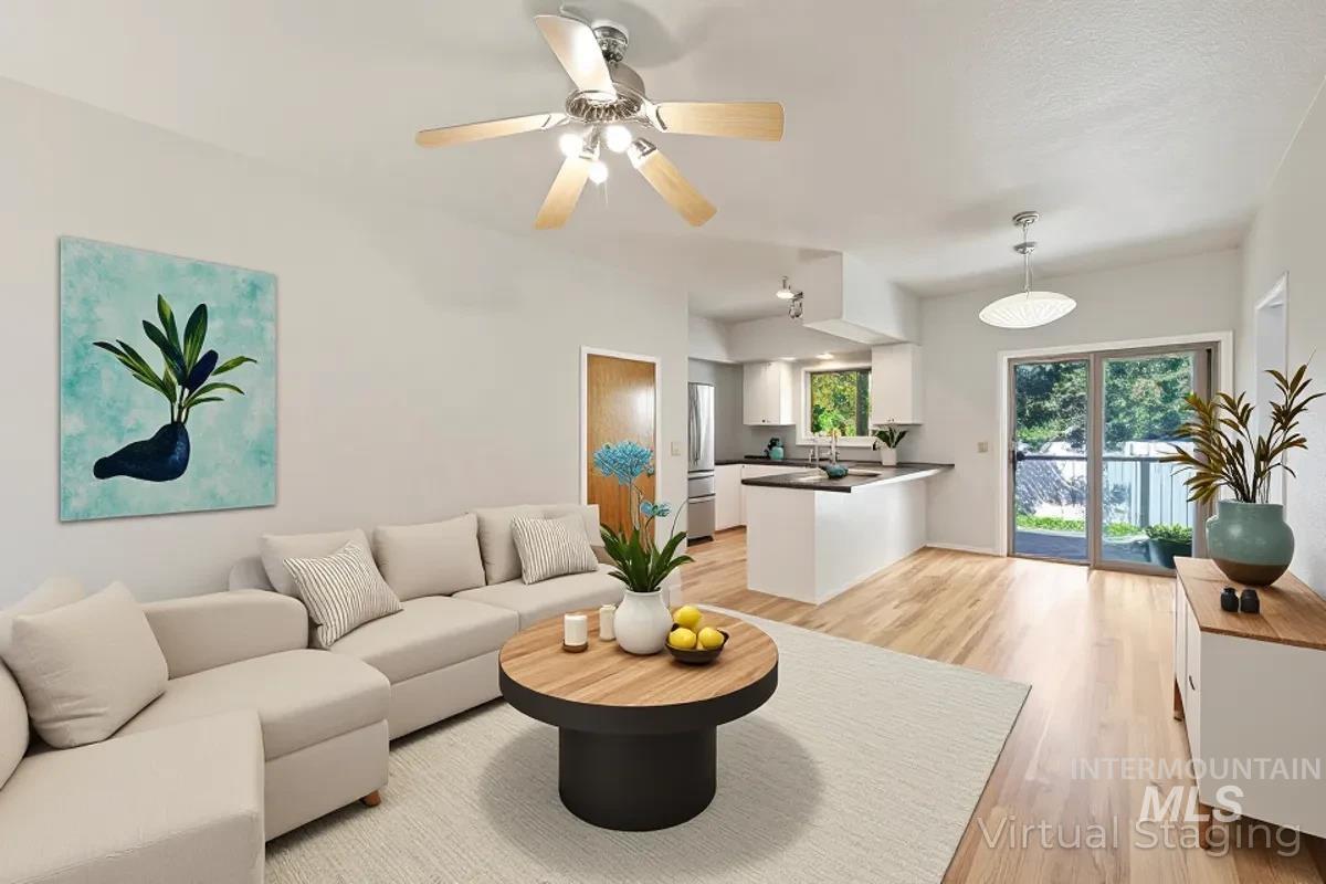 Living room with light wood finished floors and ceiling fan