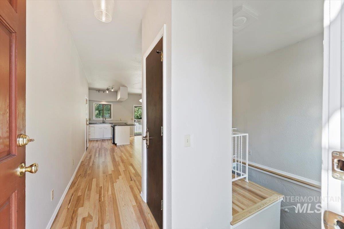 Corridor featuring light wood-style floors and baseboards