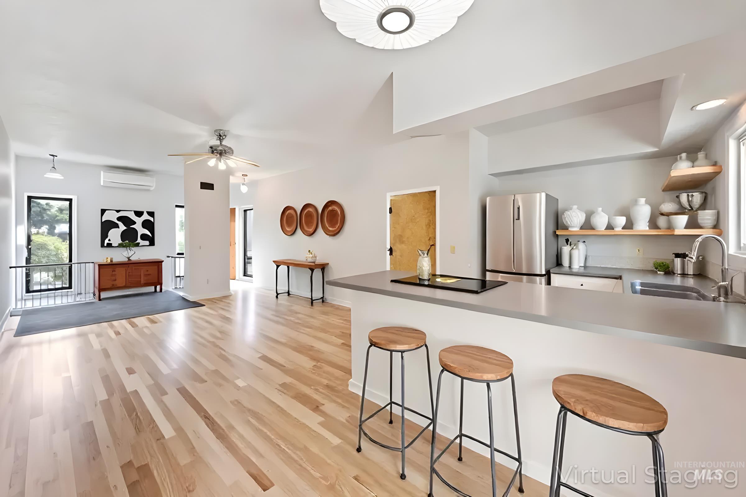 Kitchen featuring plenty of natural light, a kitchen bar, freestanding refrigerator, and light wood-style flooring
