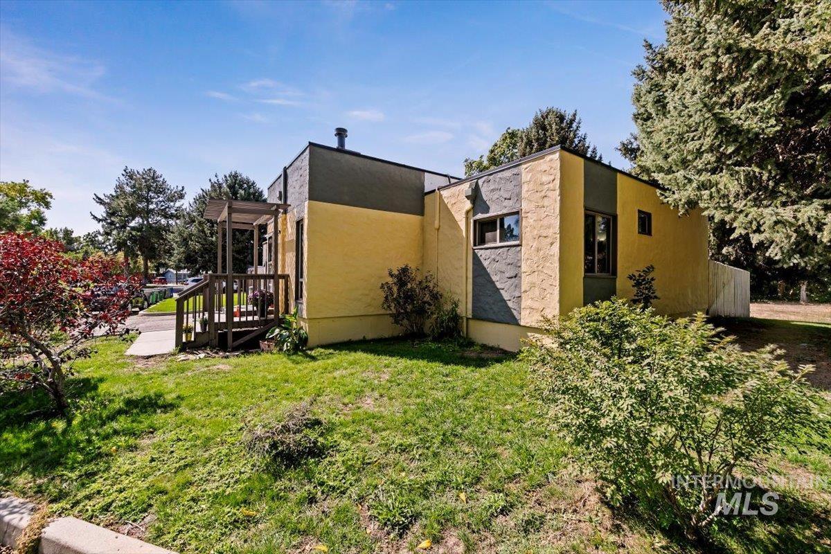 View of side of home featuring a lawn and stucco siding