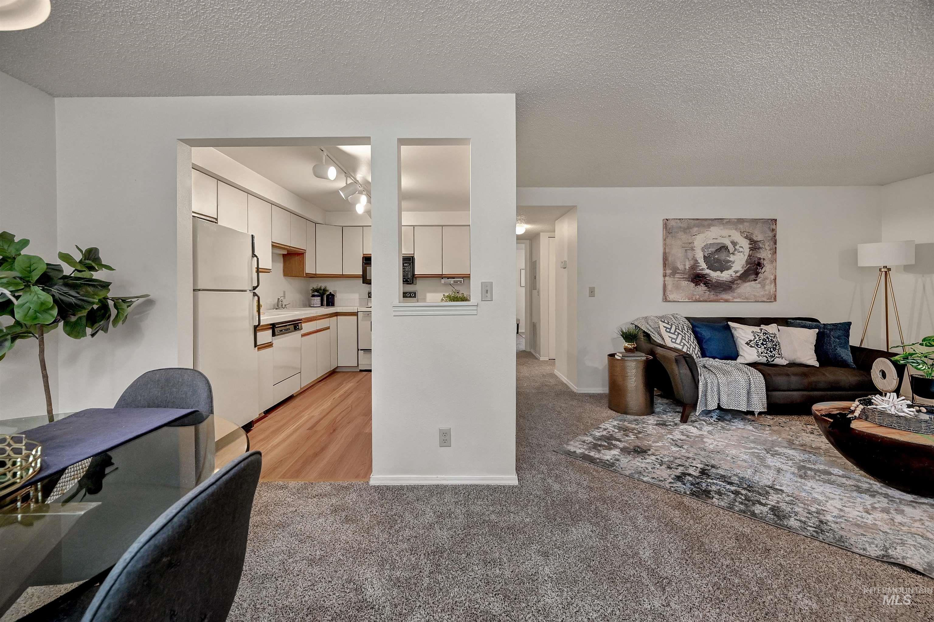 Living area with a textured ceiling and light carpet