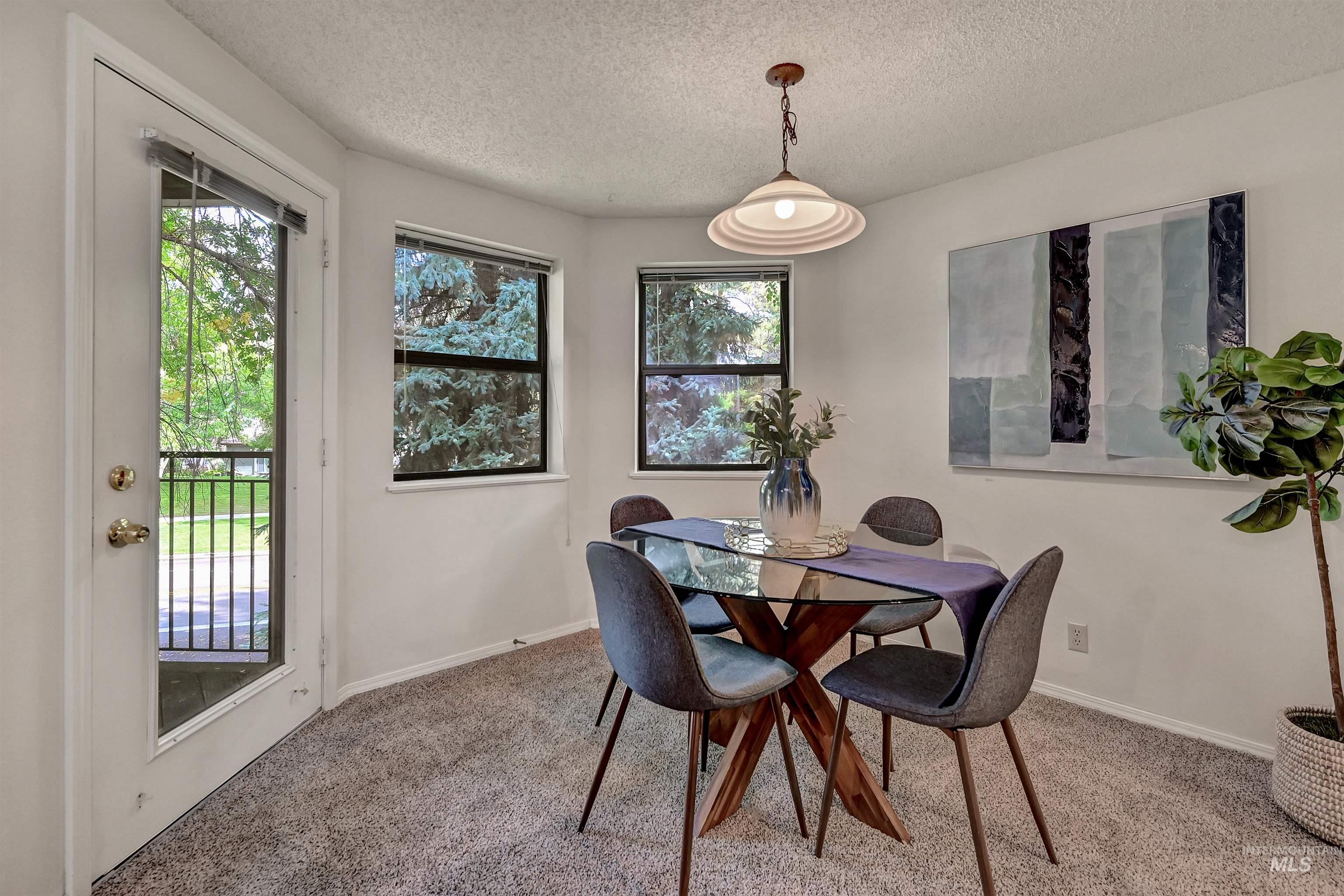 Carpeted dining area featuring a textured ceiling
