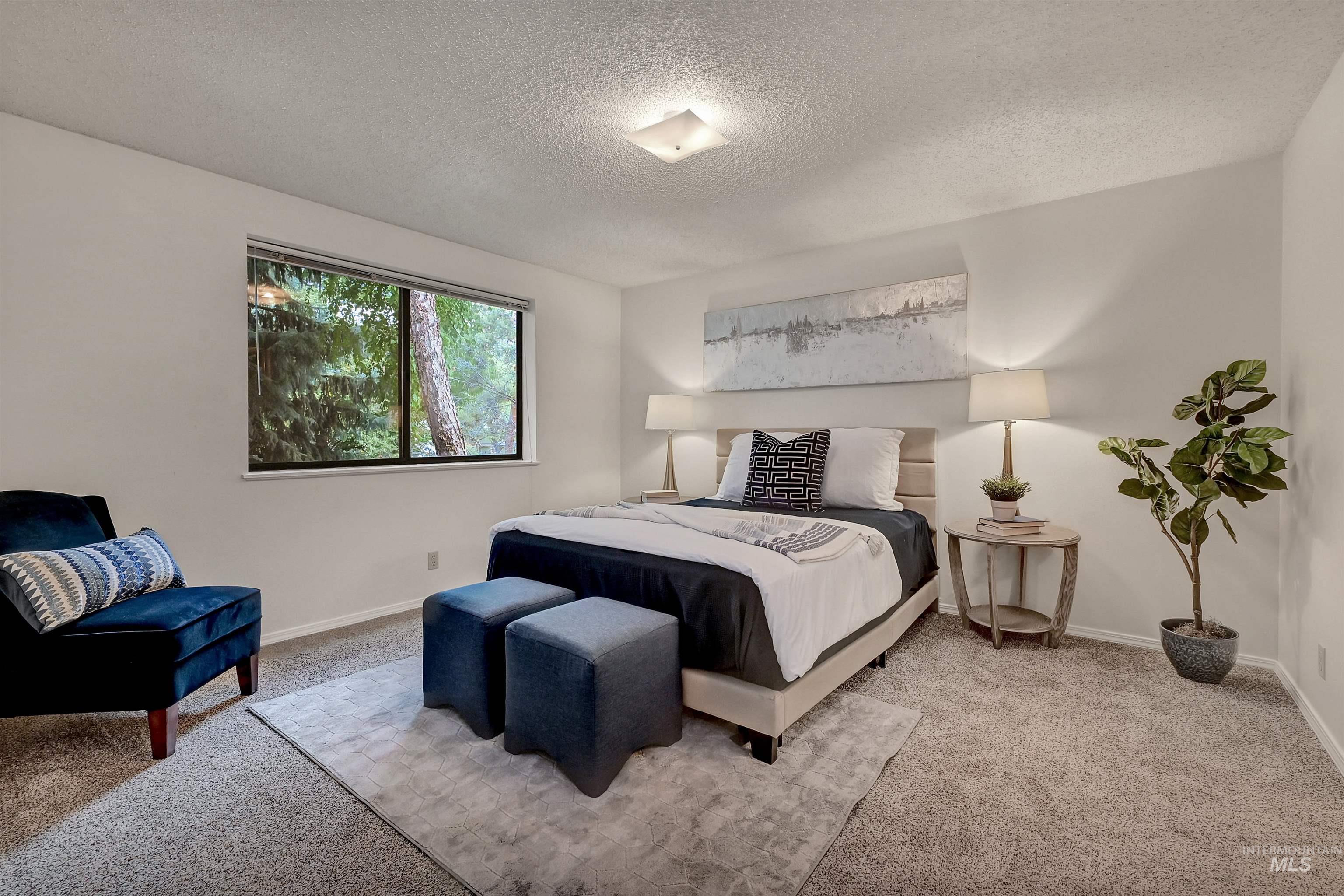 Bedroom featuring carpet and a textured ceiling