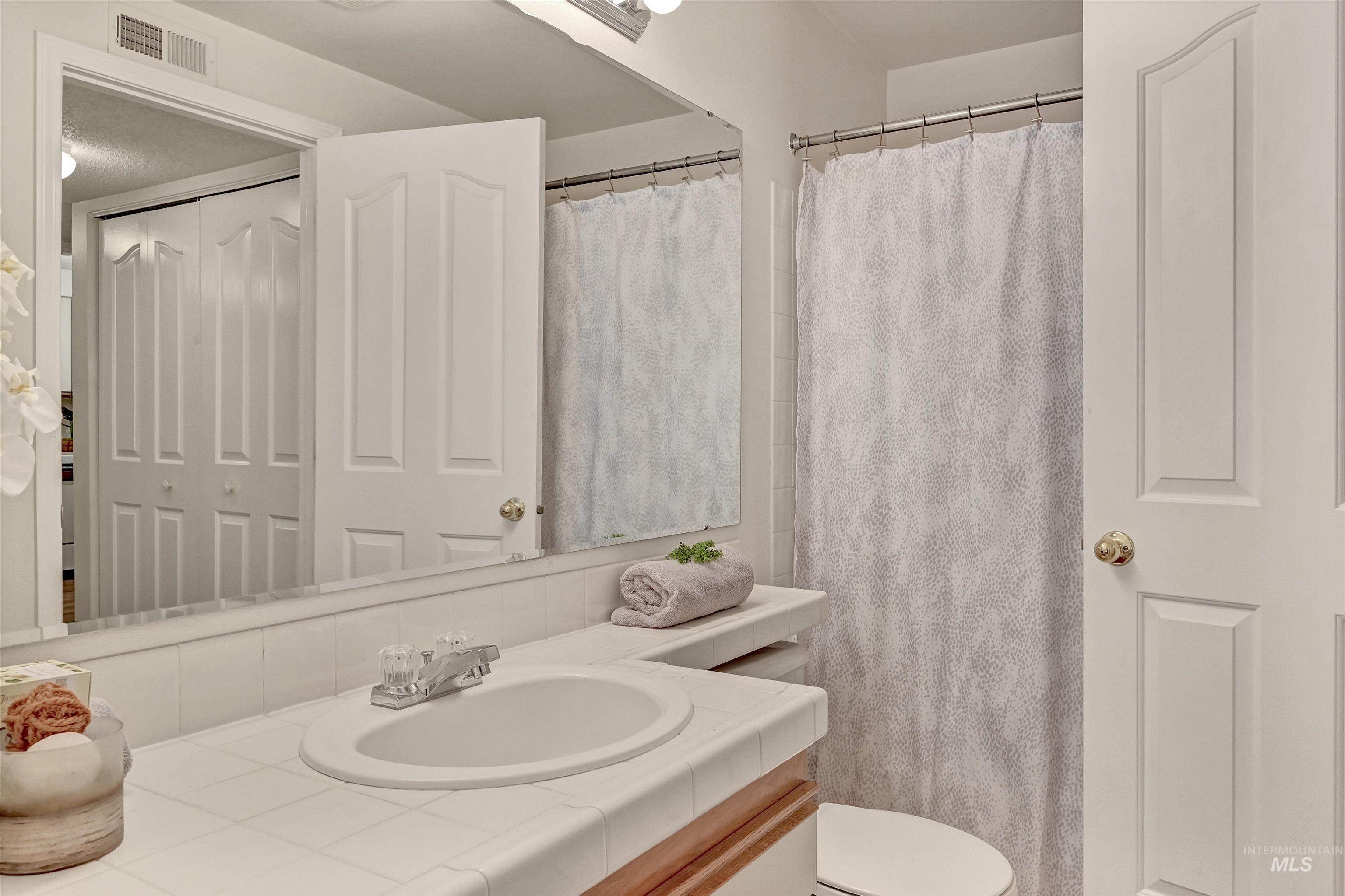 Full bath with vanity and a shower with shower curtain