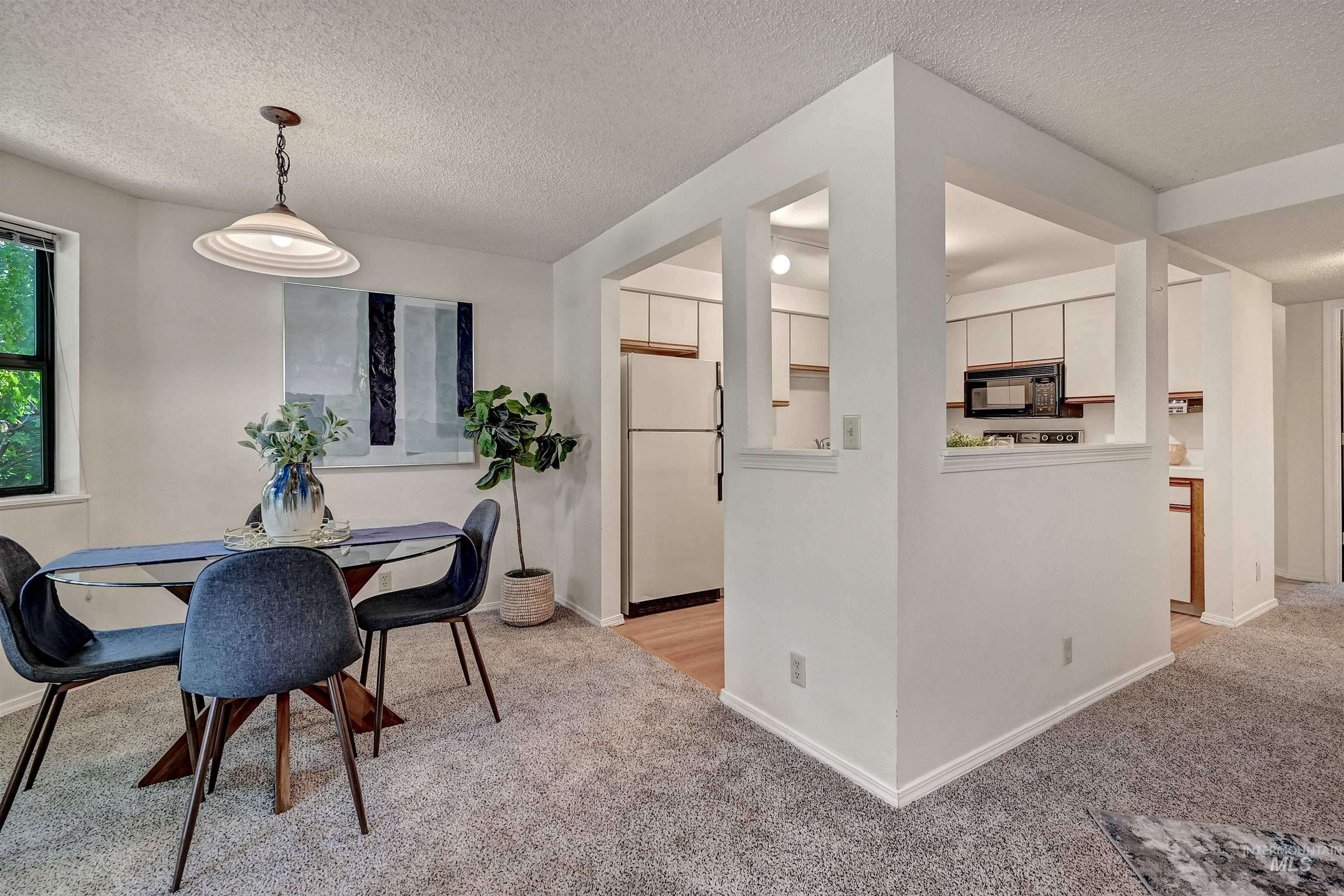 Dining room featuring a textured ceiling and light carpet
