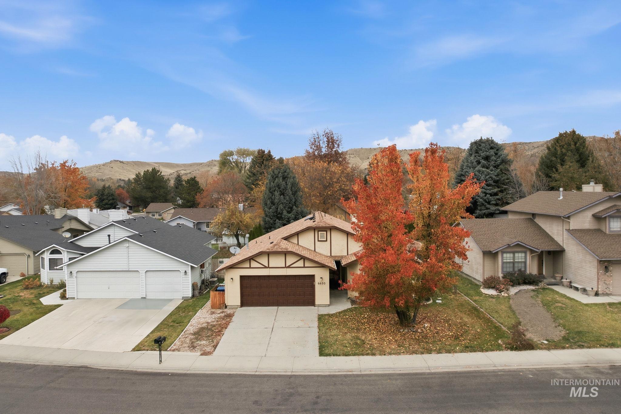 View of front facade featuring concrete driveway, a residential view, and a mountain view