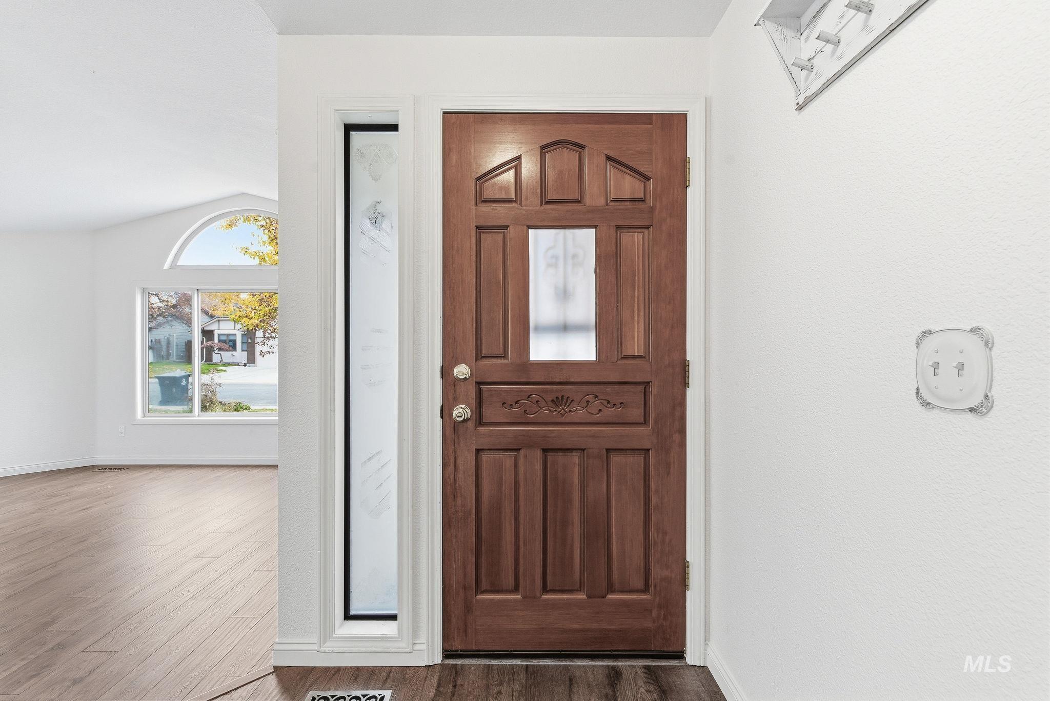 Foyer with lofted ceiling and dark wood finished floors